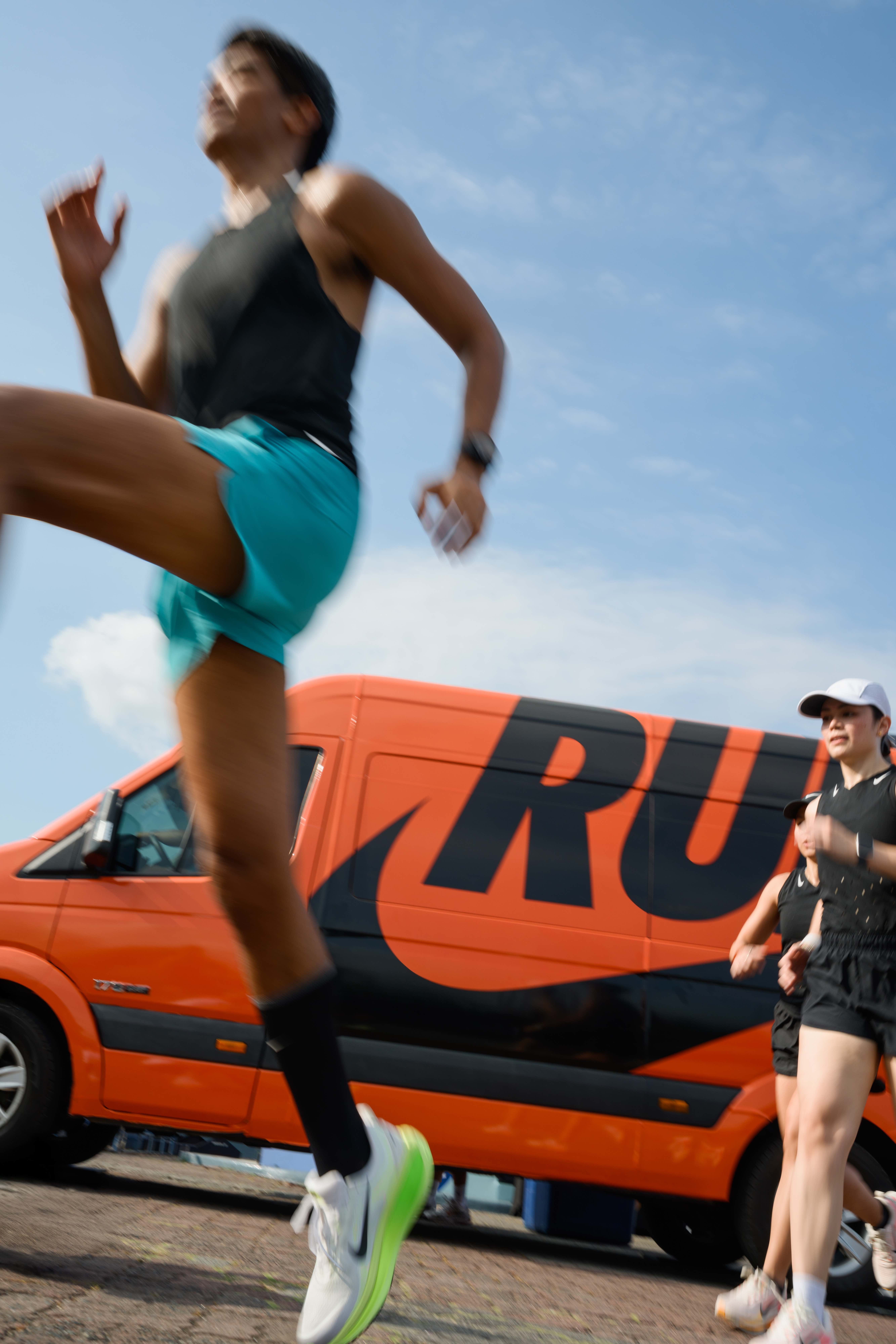 Athletic lifestyle photography with runners and orange vehicle